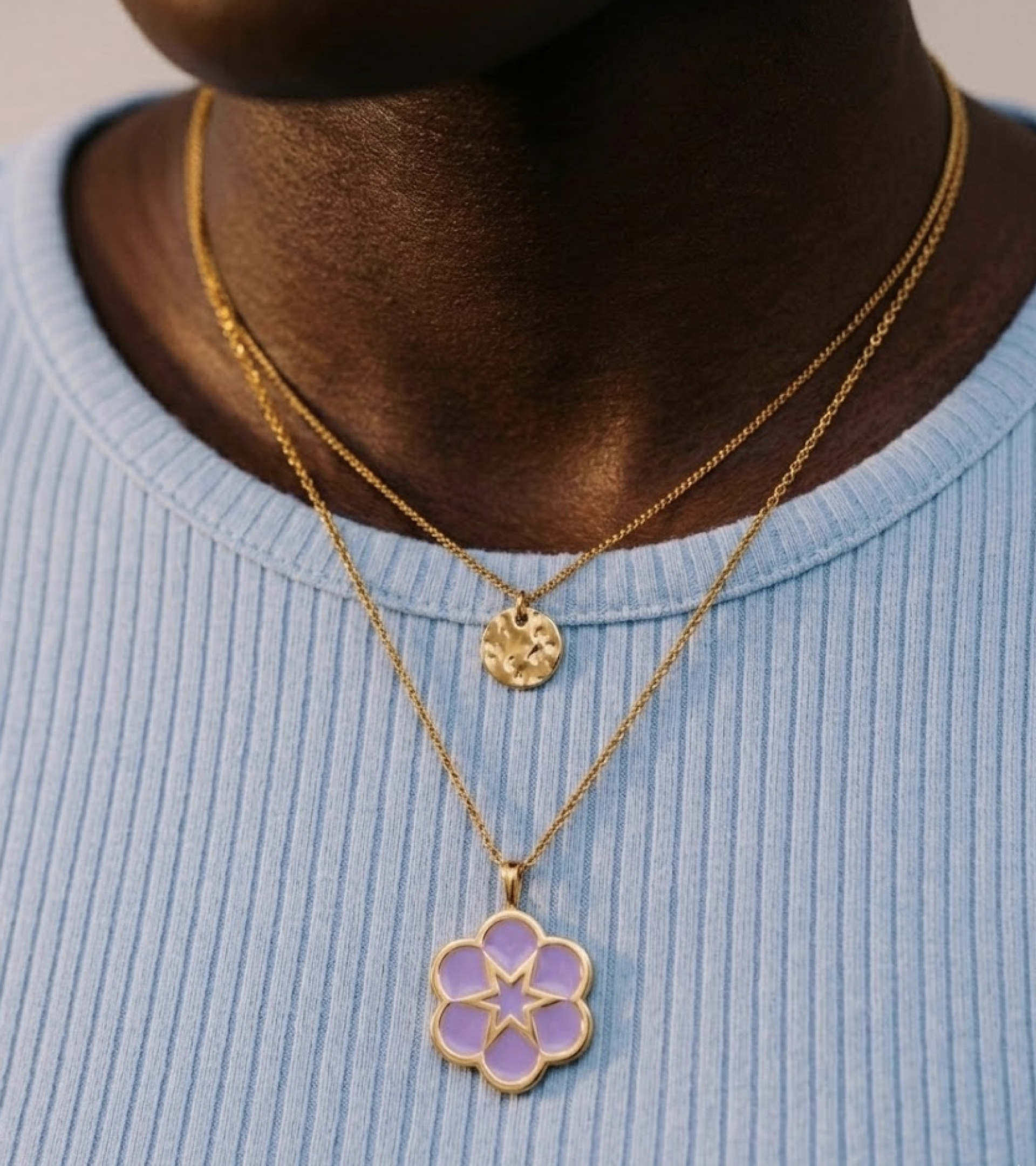 c﻿lose up of the floral symbol as a charm on a gold chain necklace