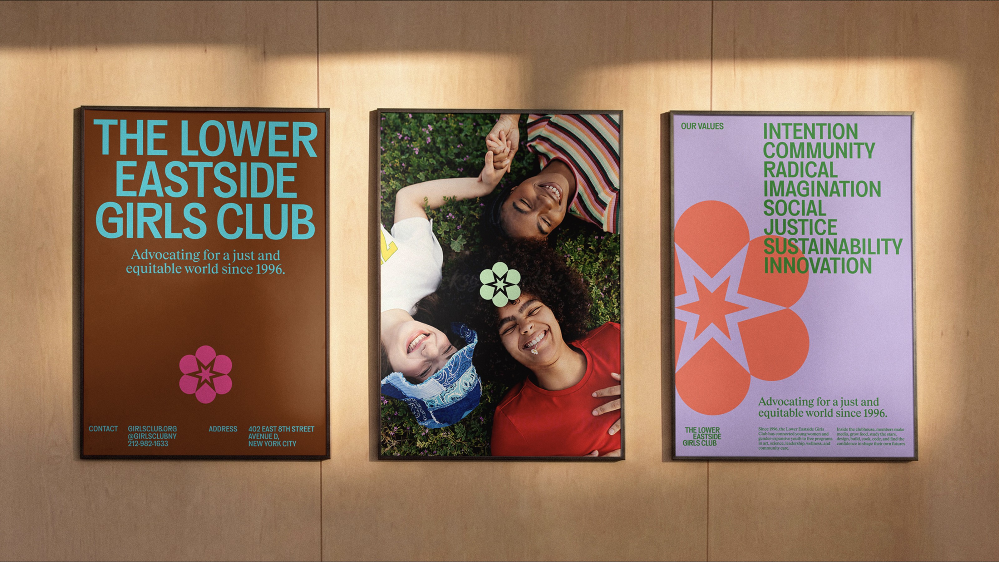 3 posters on an interior wall with logo, photo and information about the girls club’s values