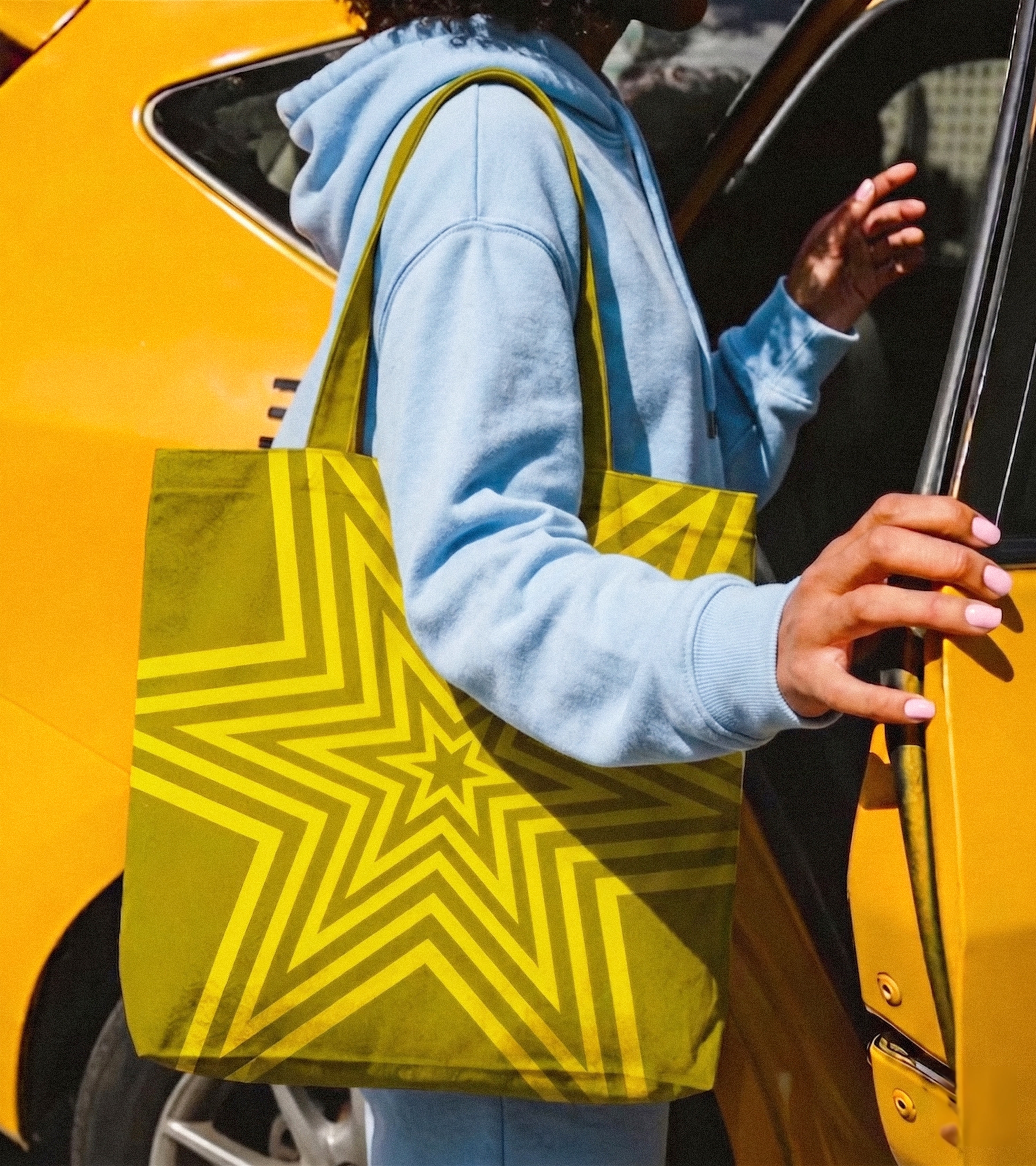 g﻿irl getting into a cab, close up on her tote bag which has a radiating star on it