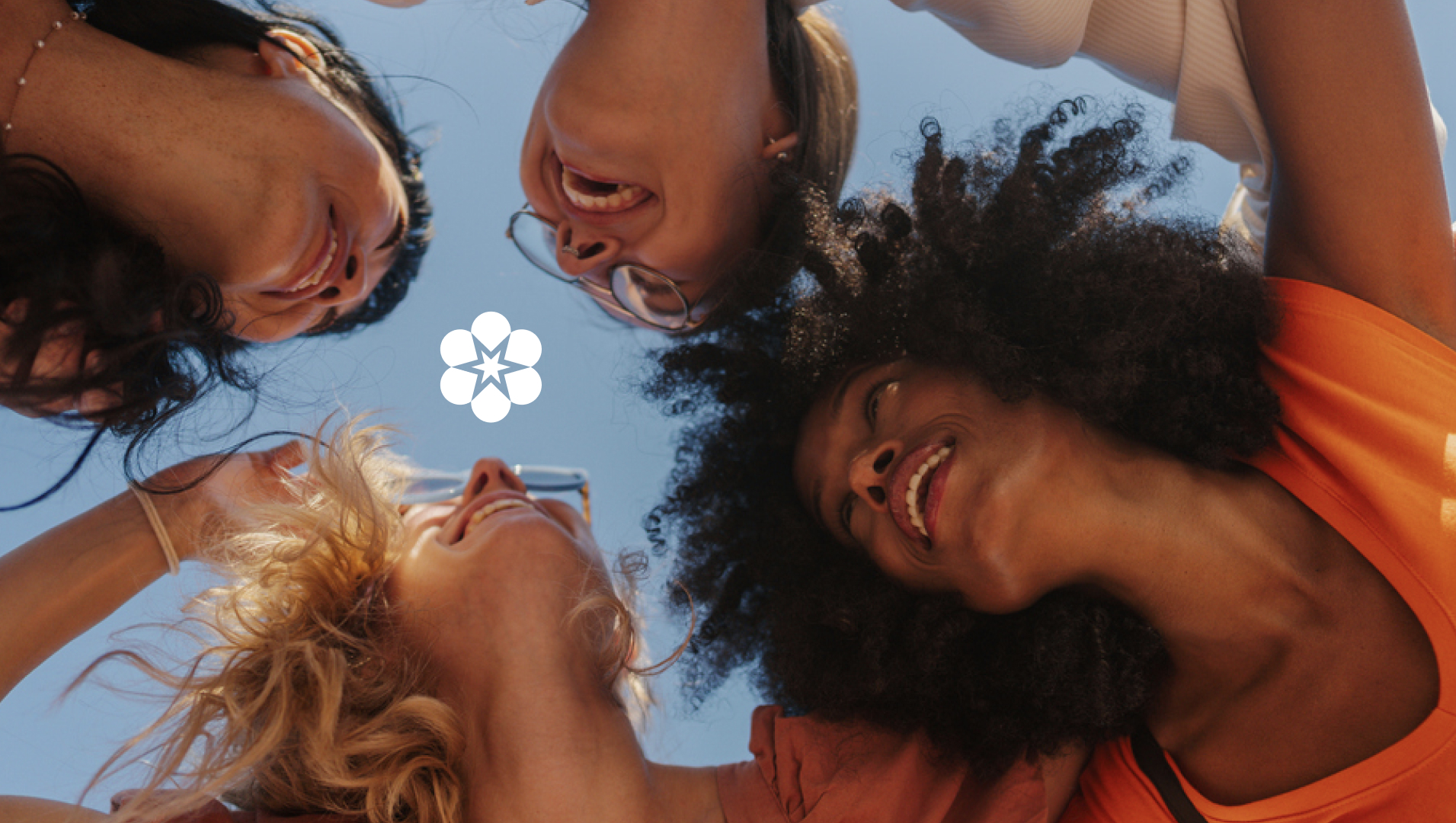 g﻿roup of girls from a dowward up perspective looking at the sky, the floral logo in the center