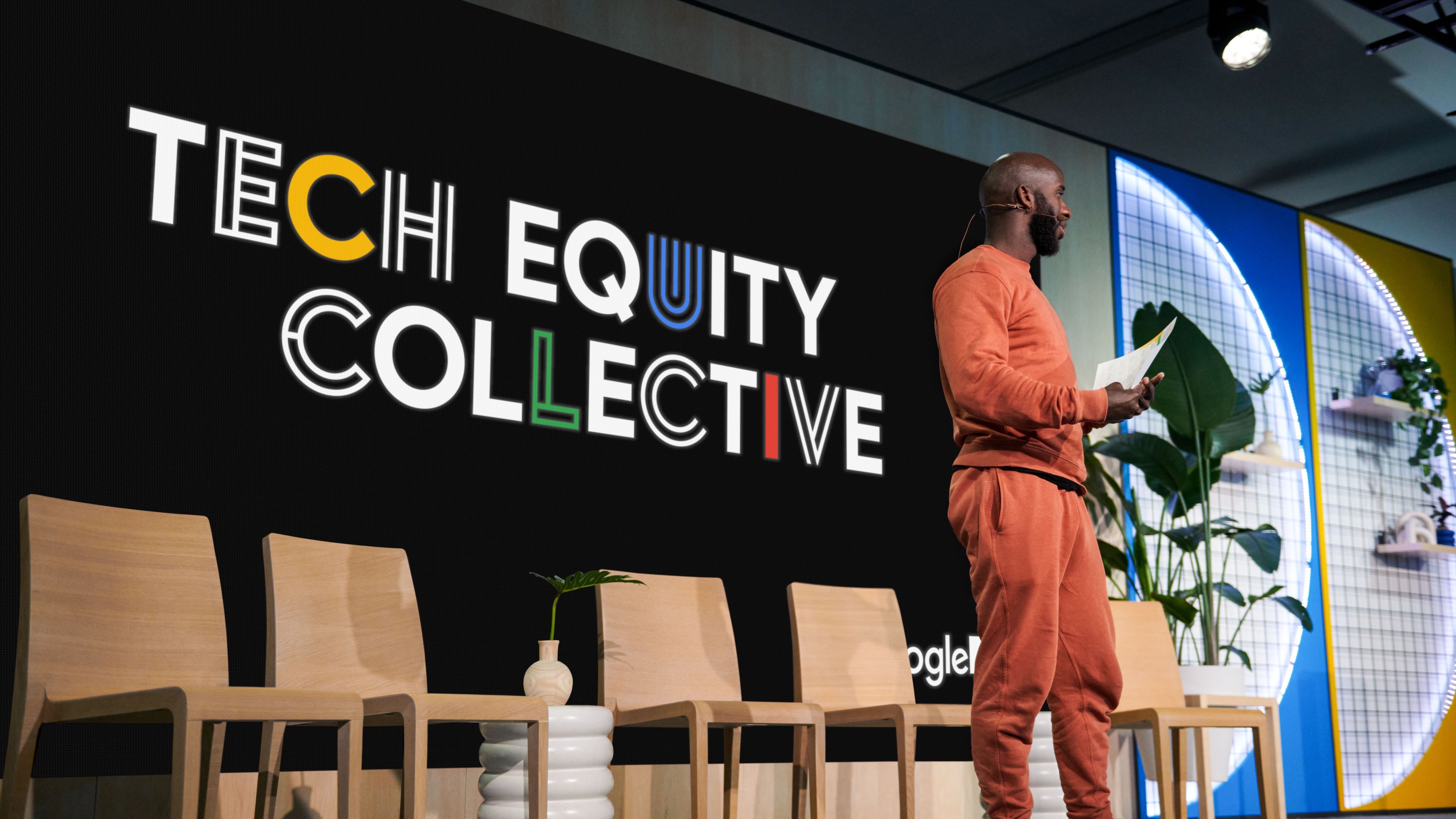 speaker on stage in front of a screen with Tech Equity Collective logo